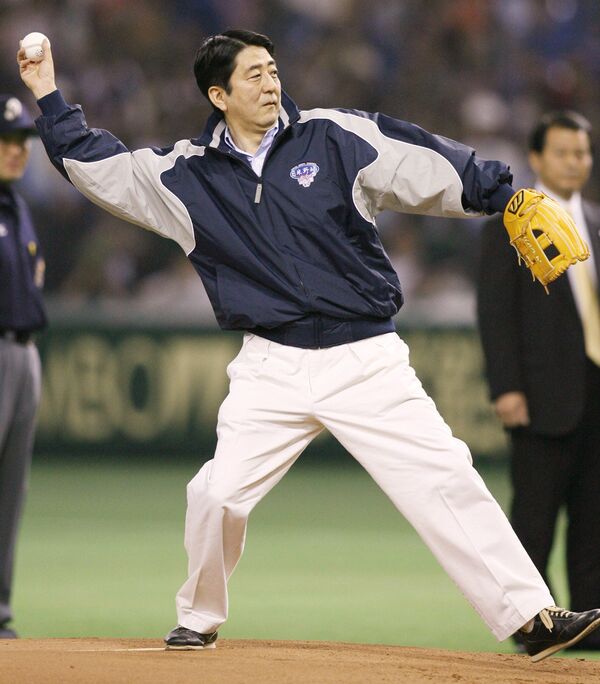 Премьер-министр Японии Синдзо Абэ бросает мяч