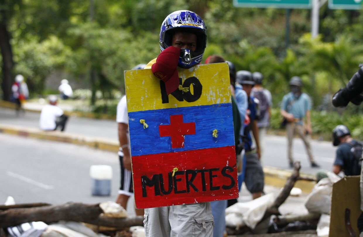 Мужчина с щитом Больше никаких смертей во время простестов в Каракасе, Венесуэла. 30 июля 2017
