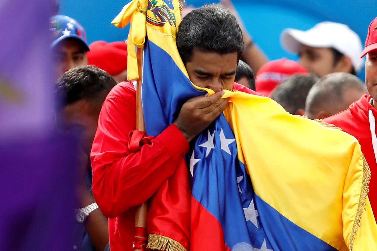 Президент Венесуэлы Николас Мадуро целует флаг страны в знак окончания предвыборной компании в Учередиельное собрание. 27 июля 2017