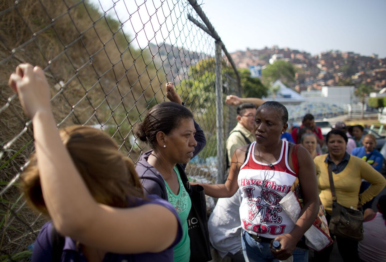 Люди стоят в очереди, чтобы купить продукты в Каракасе