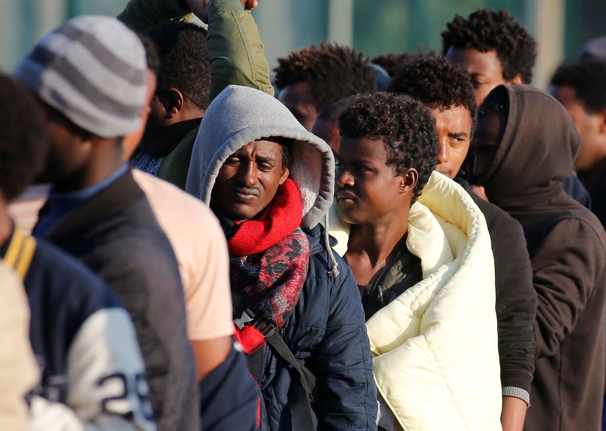 Мигранты из Эфиопии и Эритреи во время распределения продовольствия в Кале
