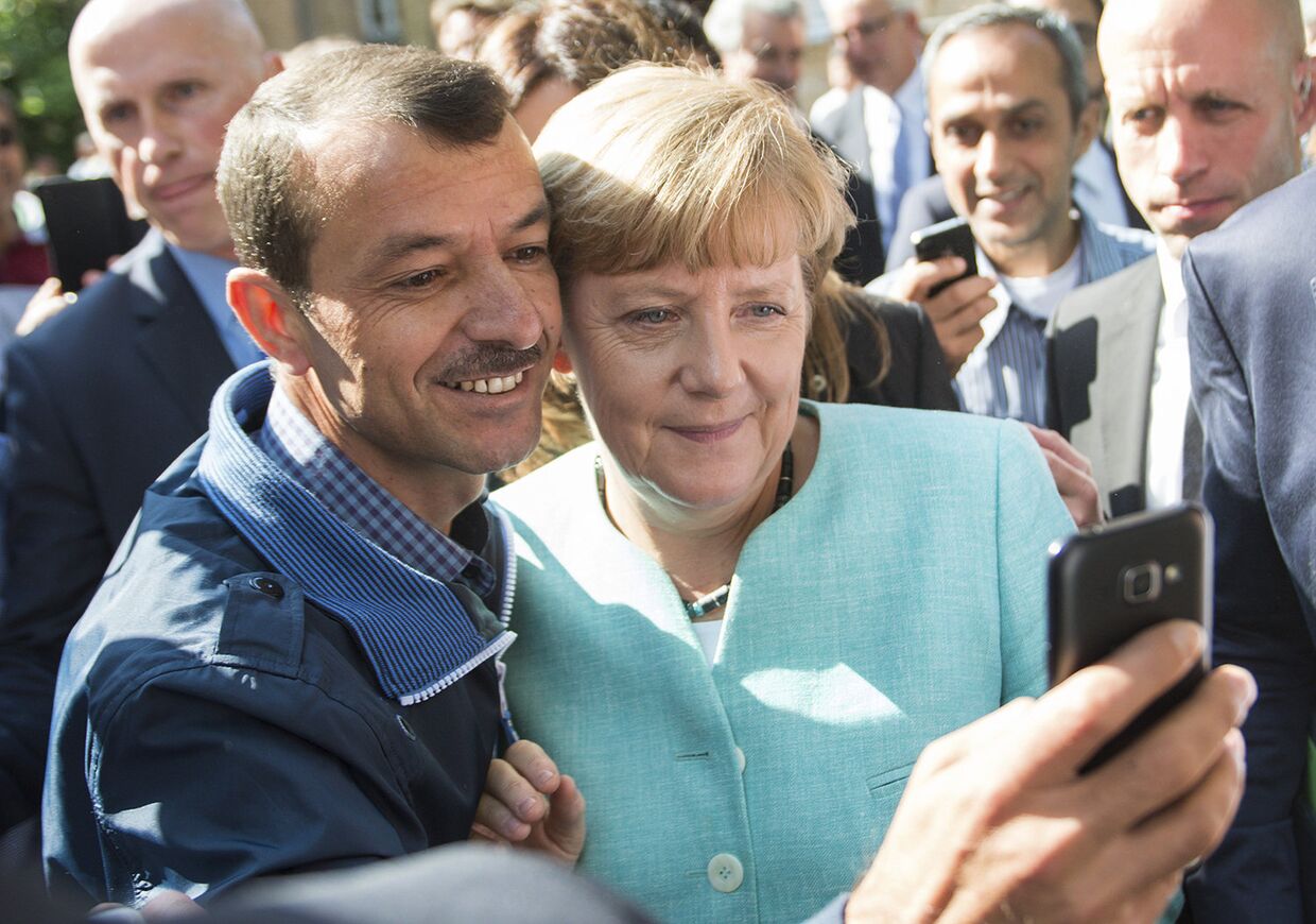 Канцлер Германии Ангела Меркель фотографируется с беженцами в Берлине