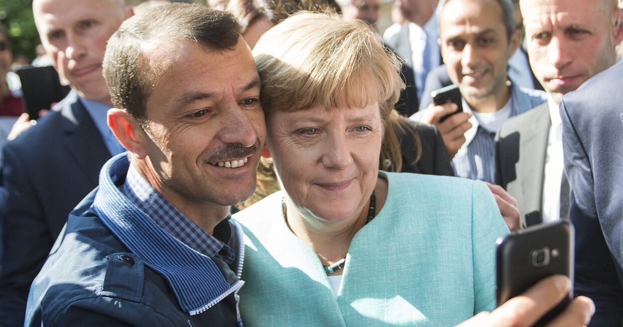 Канцлер Германии Ангела Меркель фотографируется с беженцами в Берлине