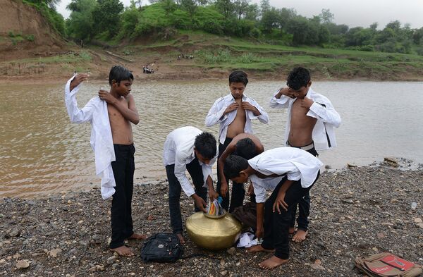 Школьники из индийской деревни Саджанпура переплывают реку Хиран