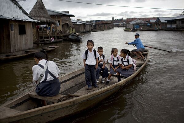 Перуанские ученики в городе Икитос плывут в школу по Амазонке