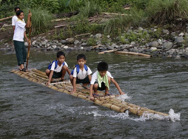 Филиппинские школьники плывут в школу на самодельном плоту