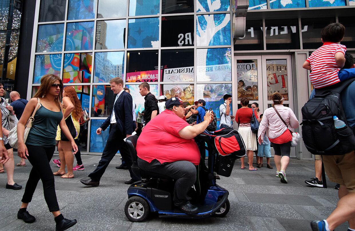 Мужчина с ожирением на электрическом самокате в Нью-Йорке