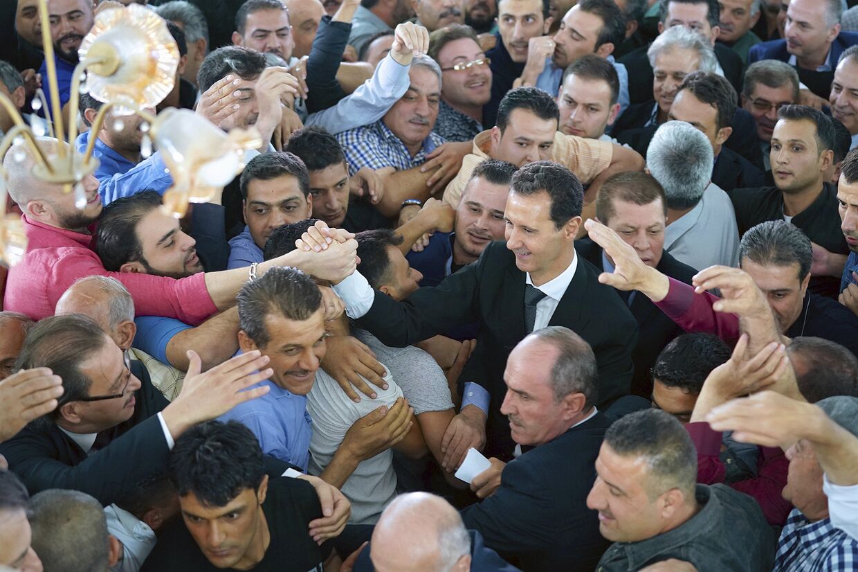 Президент Сирии Башар Асад приветствует сирийцев после молитвы в мечети Билал в городе Каламун, Сирия