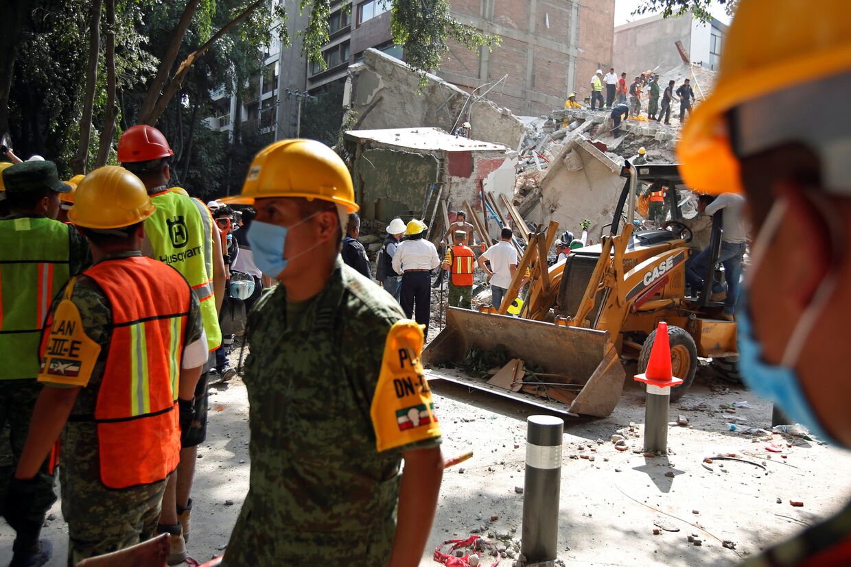 Солдаты и добровольцы работают на месте разрушенного землетрясением здания в Мехико