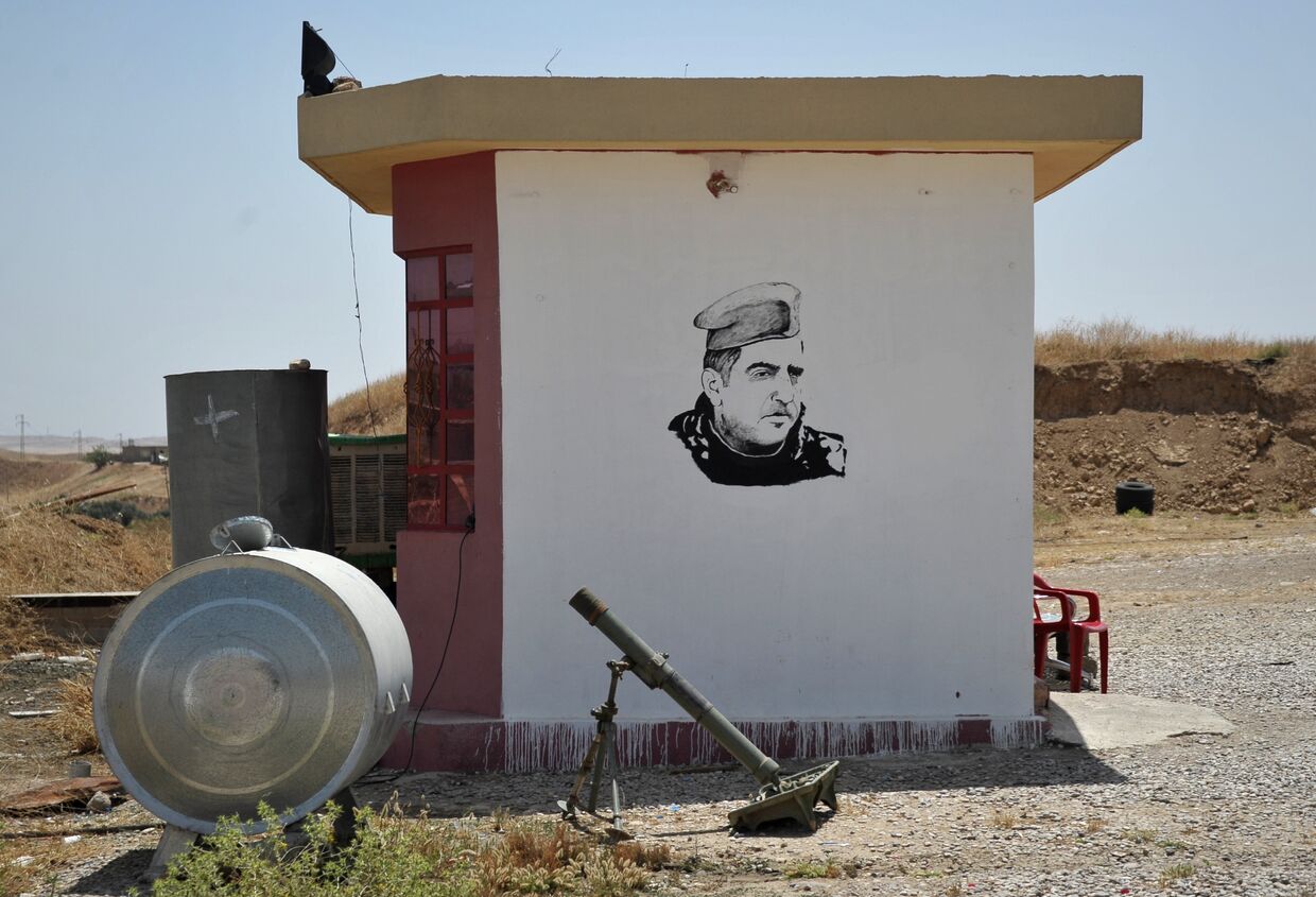 Миномет курдской пешмерга на фоне граффити с портретом президента Иракского Курдистана Масуда Барзани