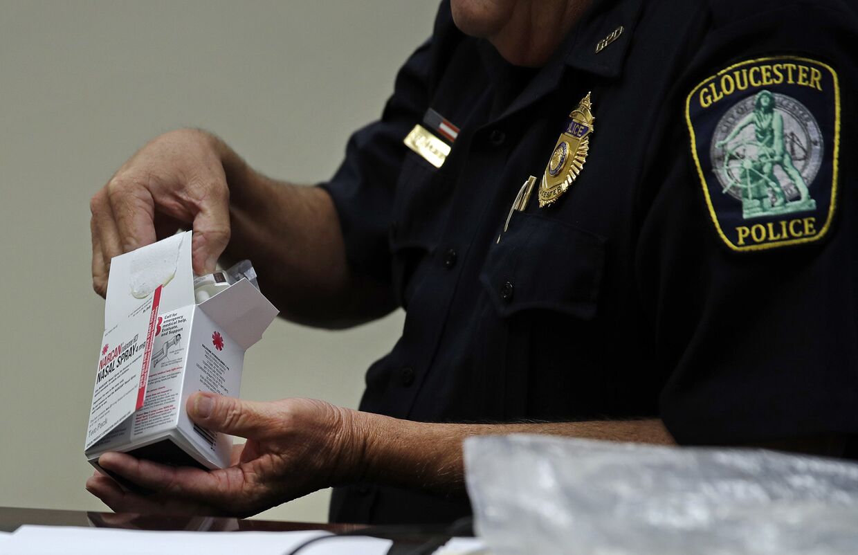 Полицейский открывает коробку с препаратом NARCAN, от передозировки наркотиками в полицейском участке в городе Глостер