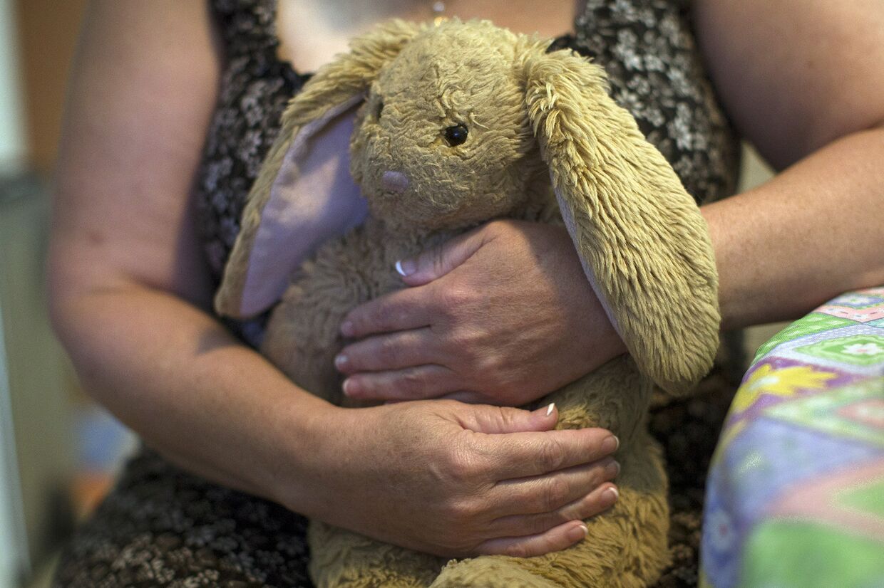 Женщина держит любимую игрушку своей 18-летней дочери, умершей от передозироовки наркотиками в Миддлтаун в США