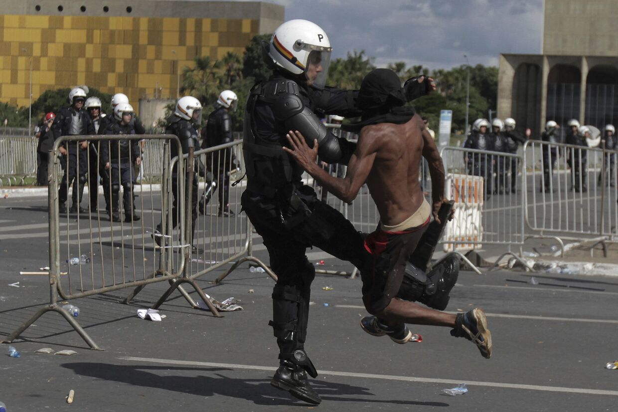 Столкновение демонстранта с полицией во время антиправительственного протеста в Бразилии