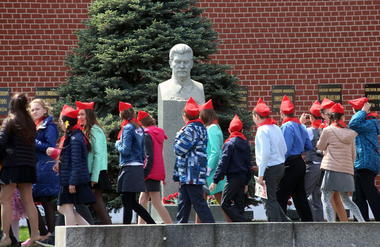 Школьники проходят мимо бюста  Иосифа Сталина