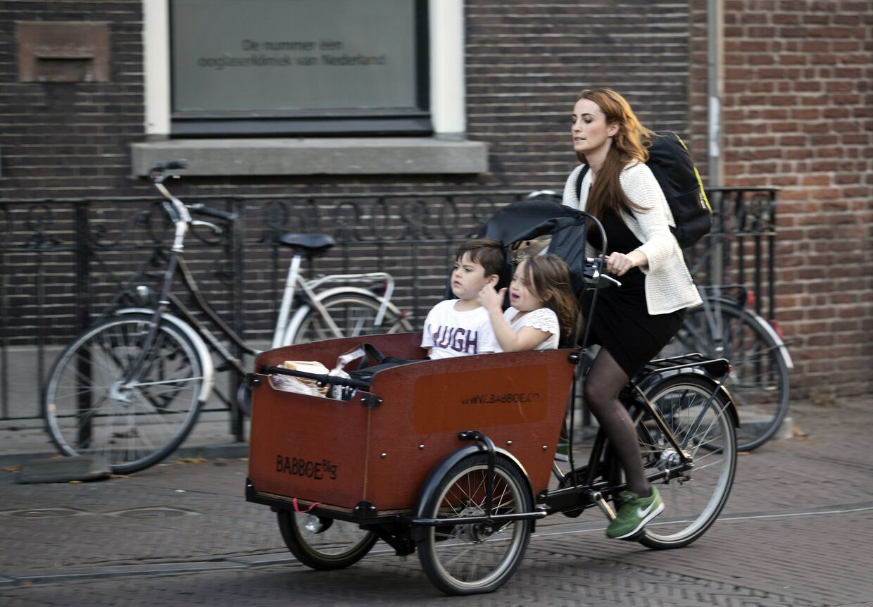 Женщина на велосипеде с детьми на одной из улиц Утрехта