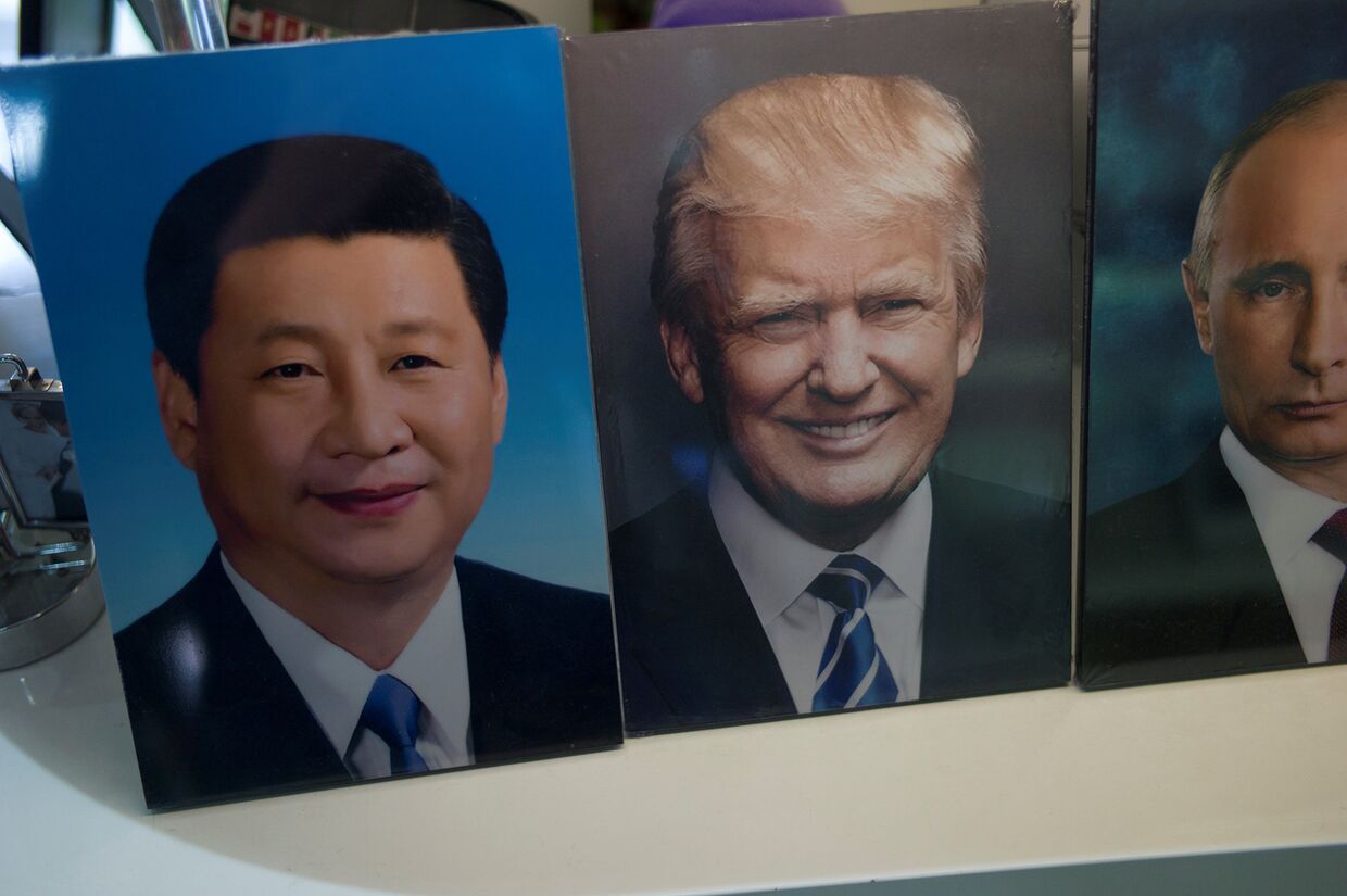Портреты председателя КНР Си Цзиньпина, президента США Дональда Трампа и президента России Владимира Путина в магазине в Пекине