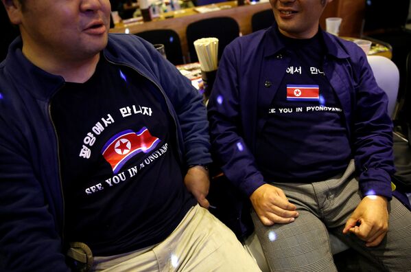 Фанаты Северной Кореи в тематических футболках на мероприятии