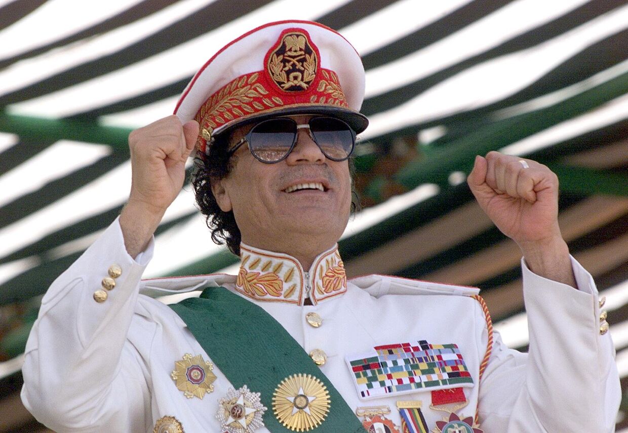 7 сентября 1999 года. Ливийский лидер Муаммар Каддафи приветствует своих солдат во время военного парада в Трипло