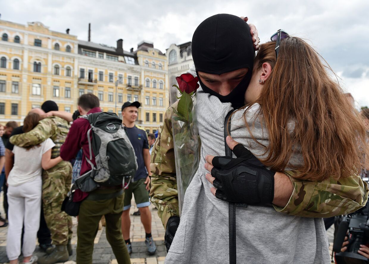 Девушка прощается с молодым человеком во время военной присяги для бойцов украинского батальона «Азов»