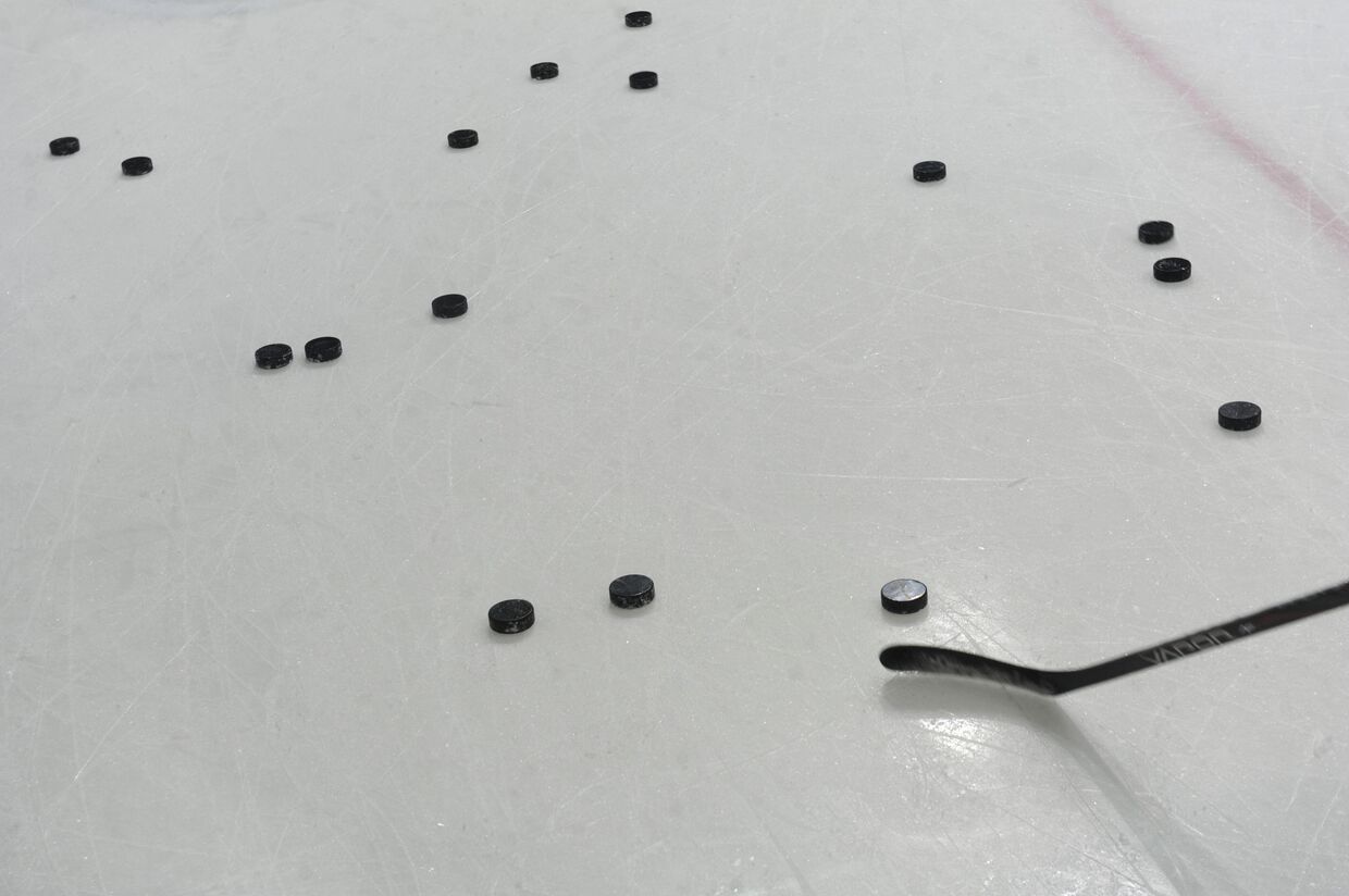 Шайбы на льду во время тренировки хоккейной команды