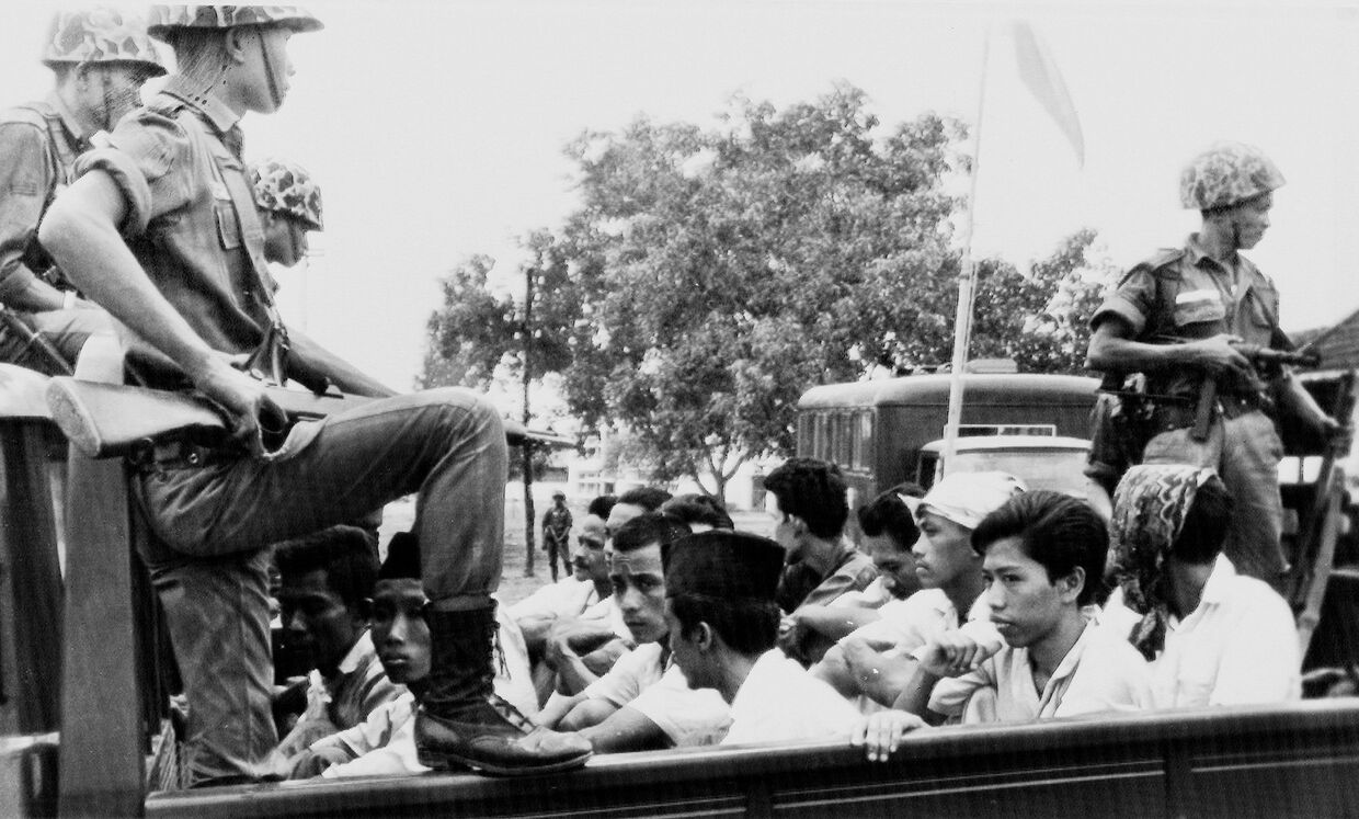 Члены молодежного крыла индонезийской Коммунистической партии, охраняемые солдатами транспортируются в тюрьму в Джакарте