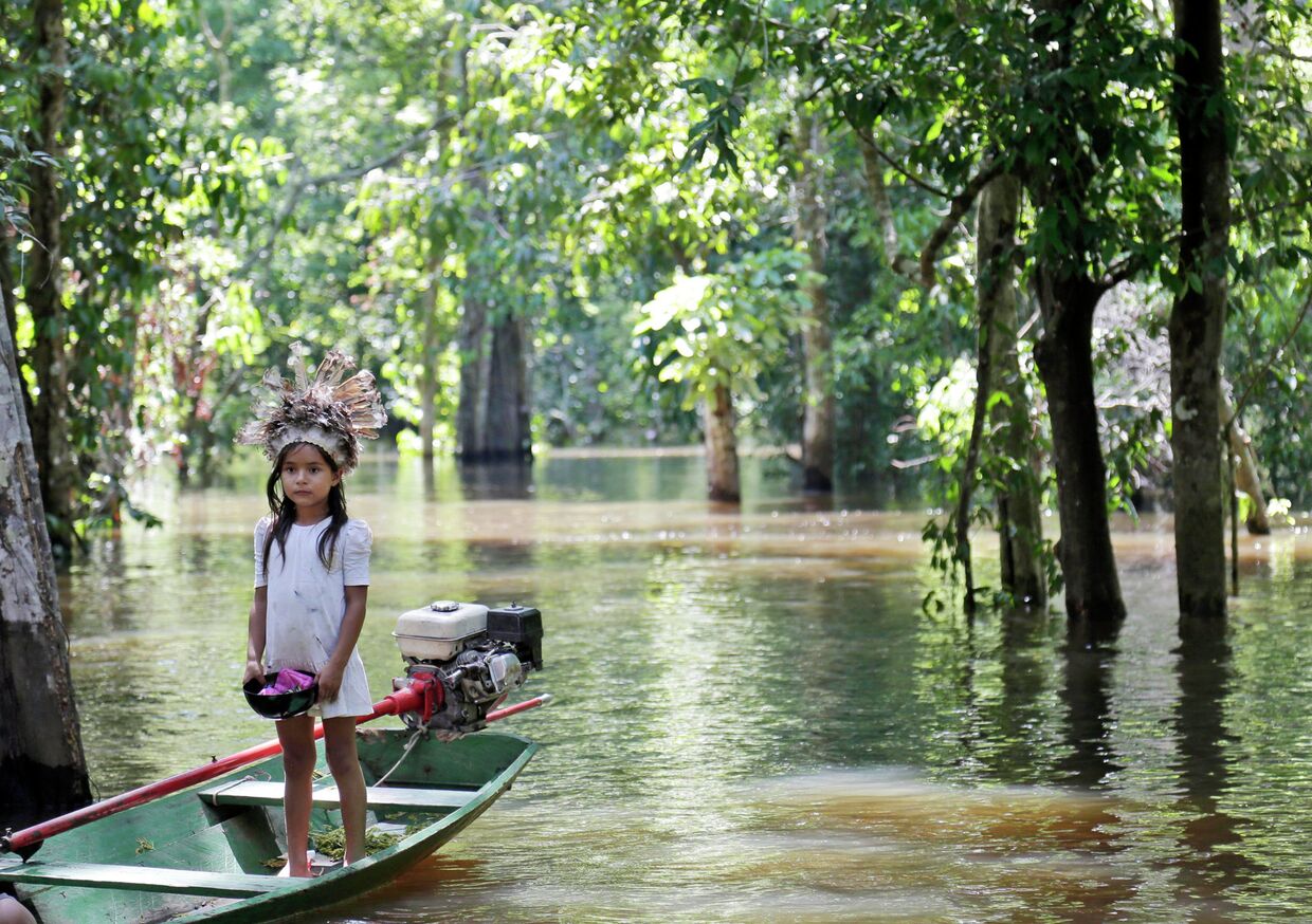 Девочка в лодке на реке Амазонка, возле города Манаус, Бразилия