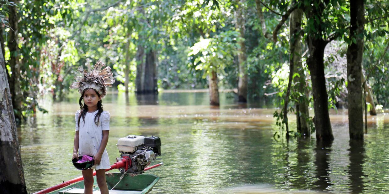 Девочка в лодке на реке Амазонка, возле города Манаус, Бразилия