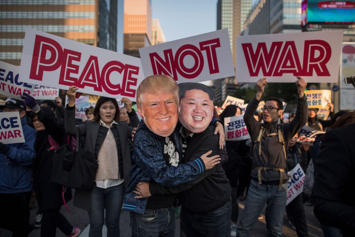 Демонстранты в масках, изображающих Дональда Трампа и Ким Чен Ына, во время митинга в Сеуле