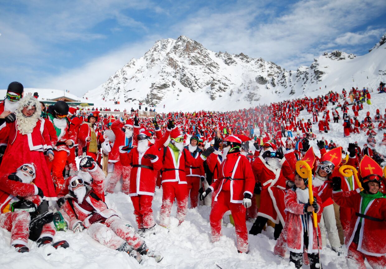 Отдыхающие в костюмах Санта-Клауса на горнолыжном курорте Вербье