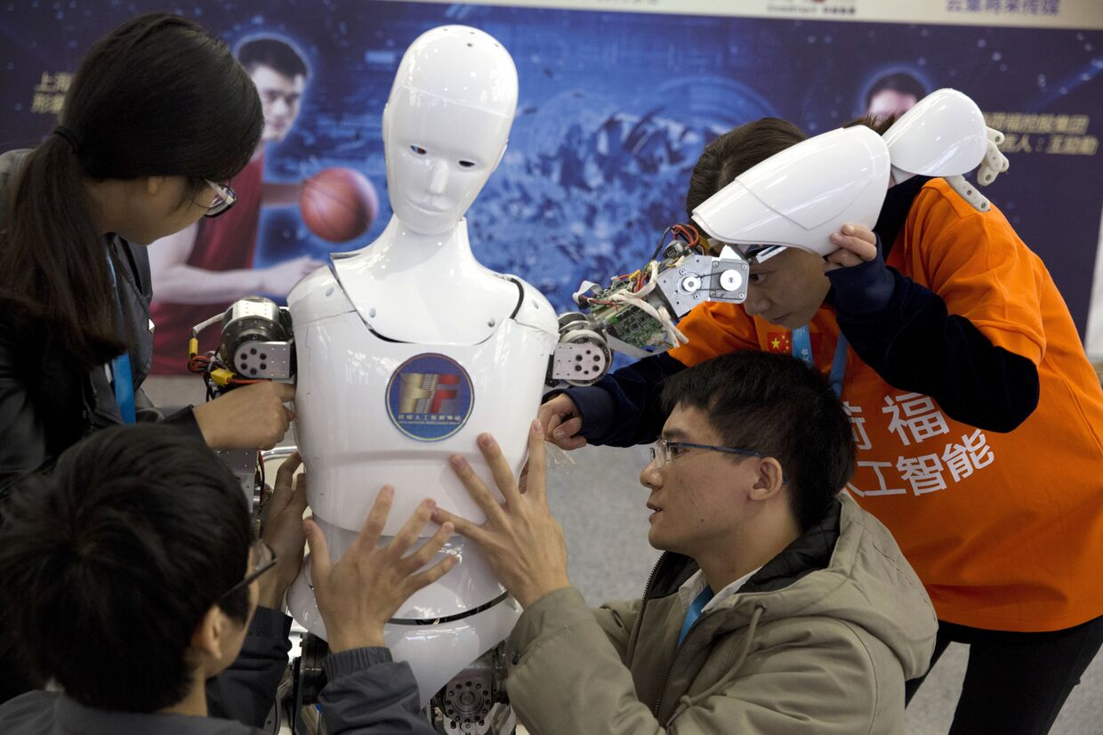 Китайские студенты собирают робота на всемирной конференции роботов в Пекине, КНР