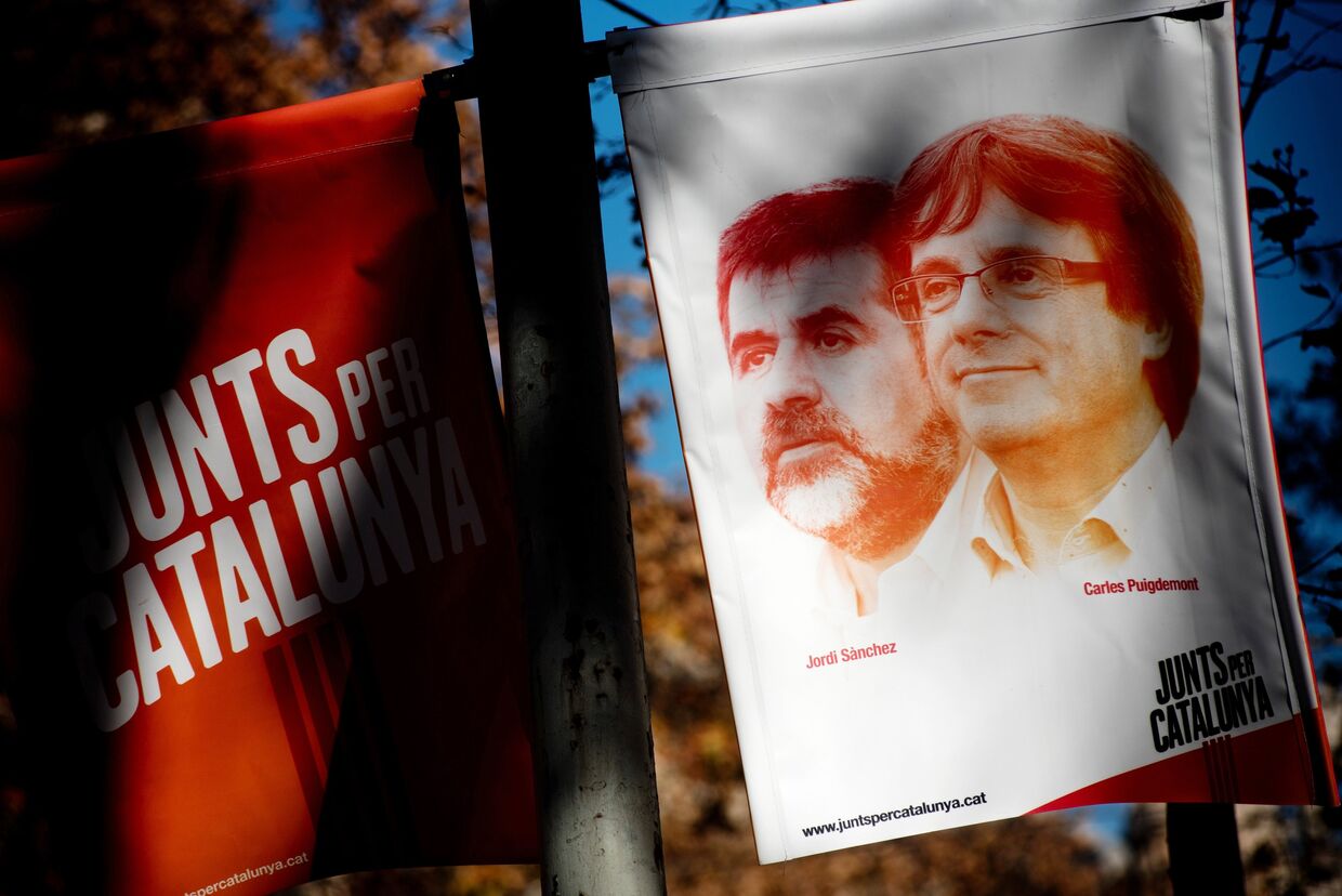 Предвыборный баннер с изображением бывшего председателя правительства Каталонии Карлеса Пучдемона и лидера Национальной ассоциация Каталонии Жорди Санчеса в Барселоне. 21 декабря 2017