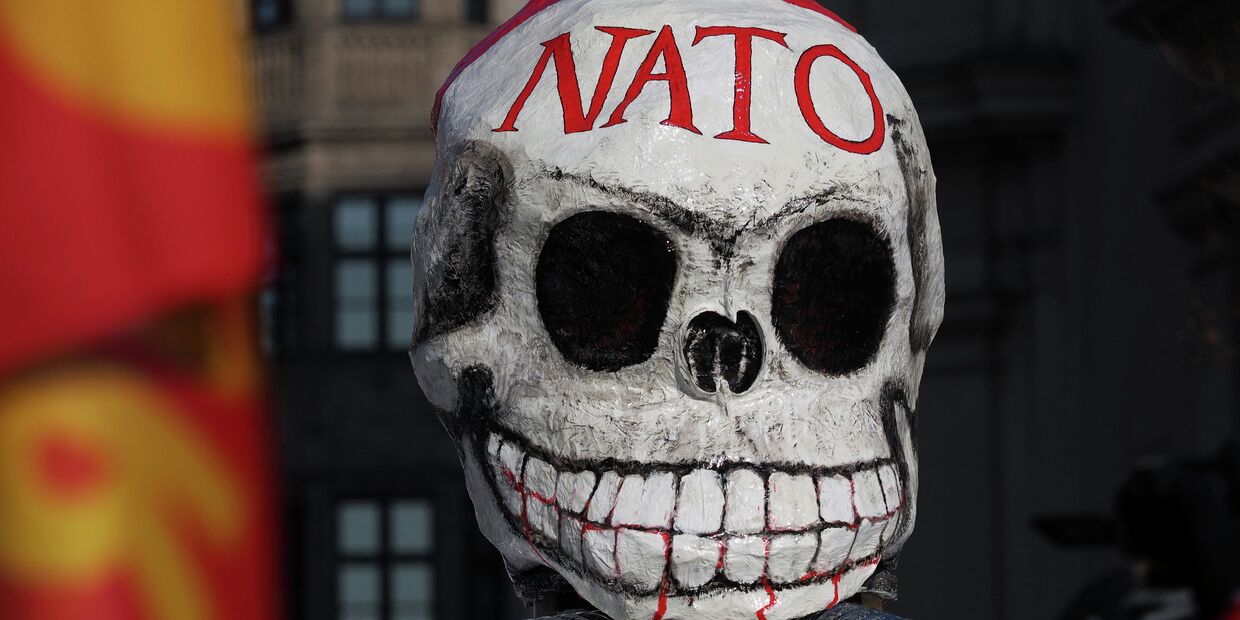 Маска на демонстрации против политики НАТО на площади у городской ратуши в Мюнхене