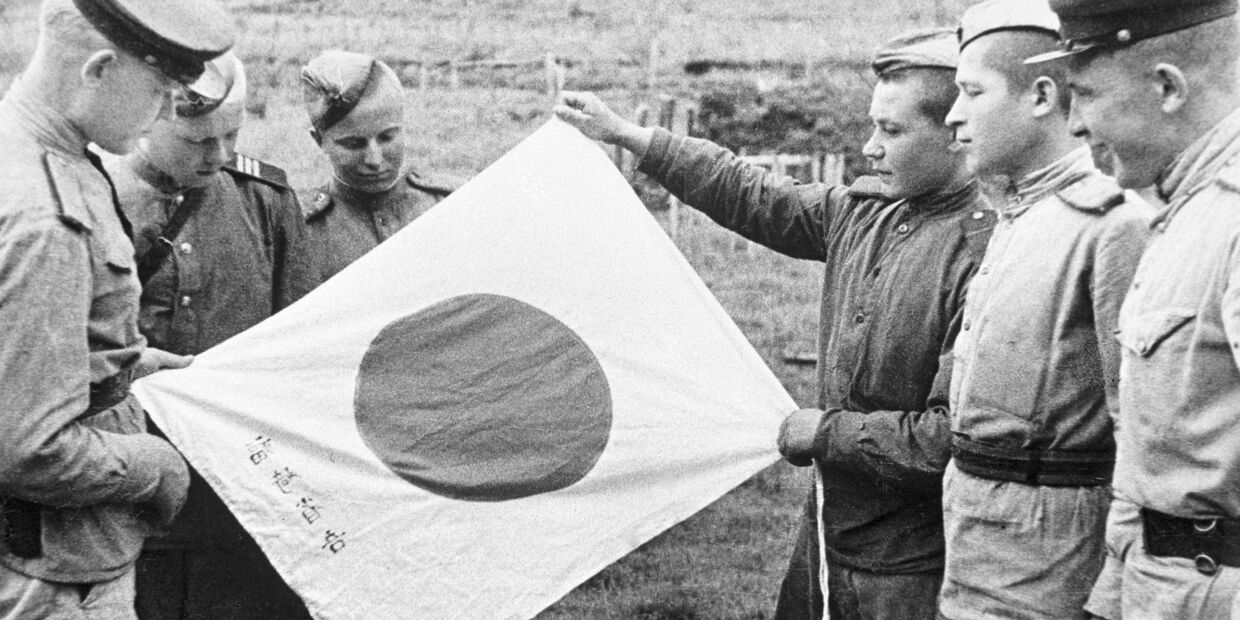 Советские воины рассматривают брошенный при отступлении японский флаг