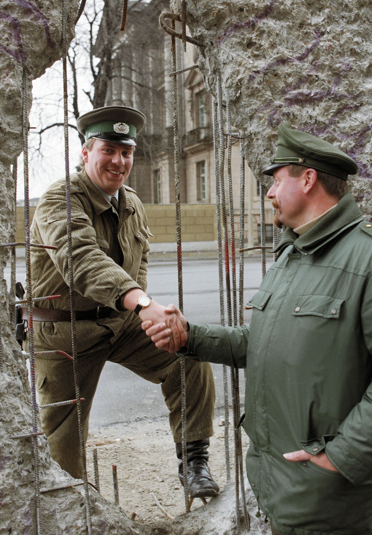 Пограничник из ГДР и полицейский из ФРГ обмениваются рукопожатием