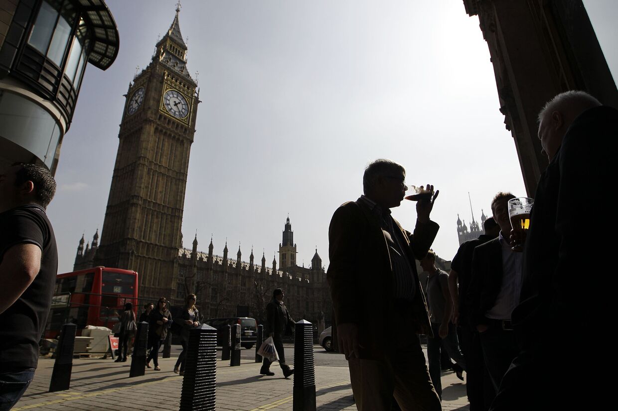 Люди наслаждаются пивом у паба напротив парламента в Лондоне