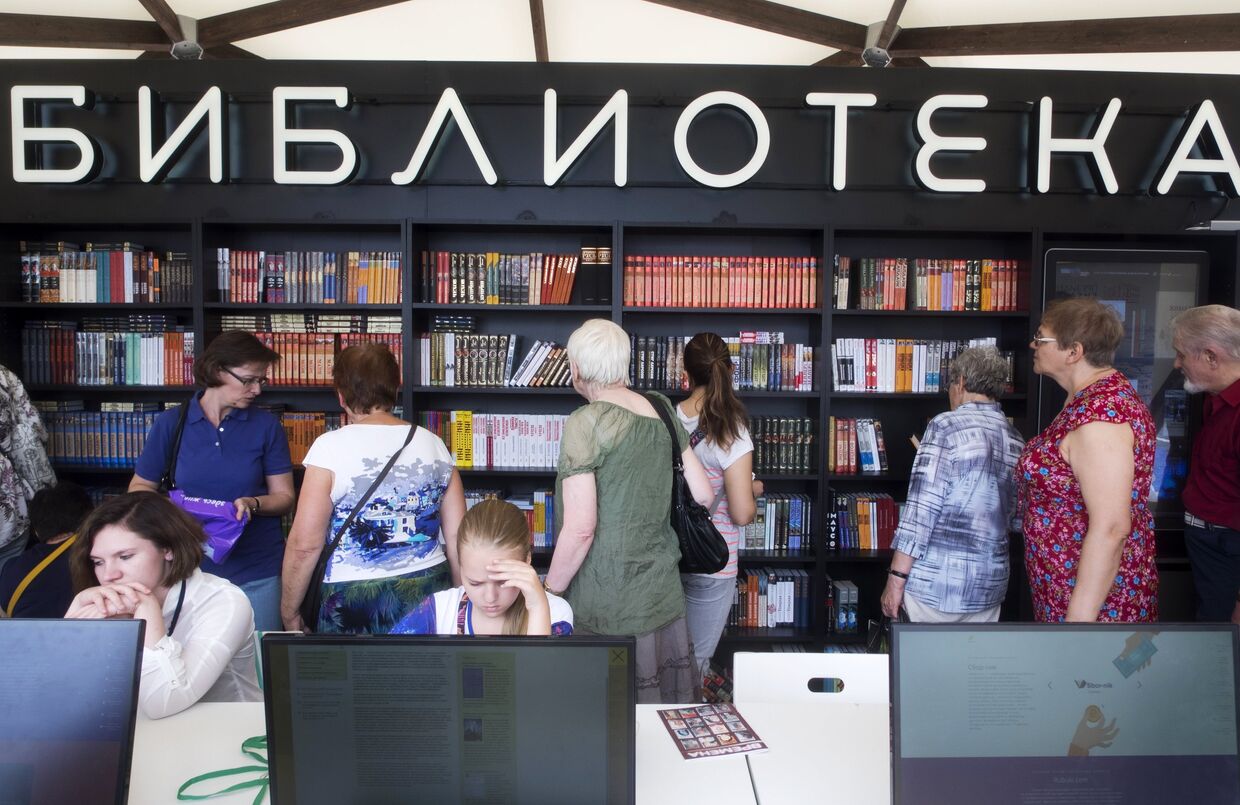 Посетители рассматривают книги на Московском фестивале Книги России на Красной площади