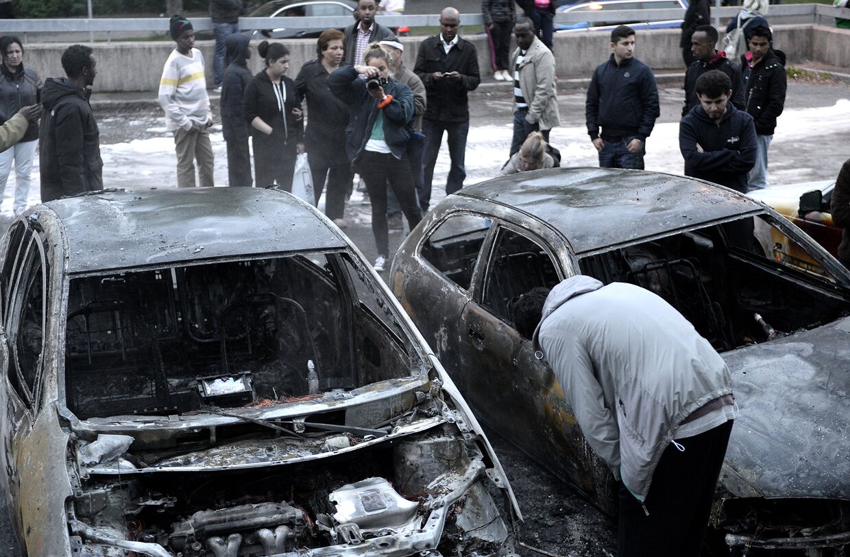 Автомобили, сгоревшие в результате акций протеста в пригороде Стокгольма Ринкеби, Швеция