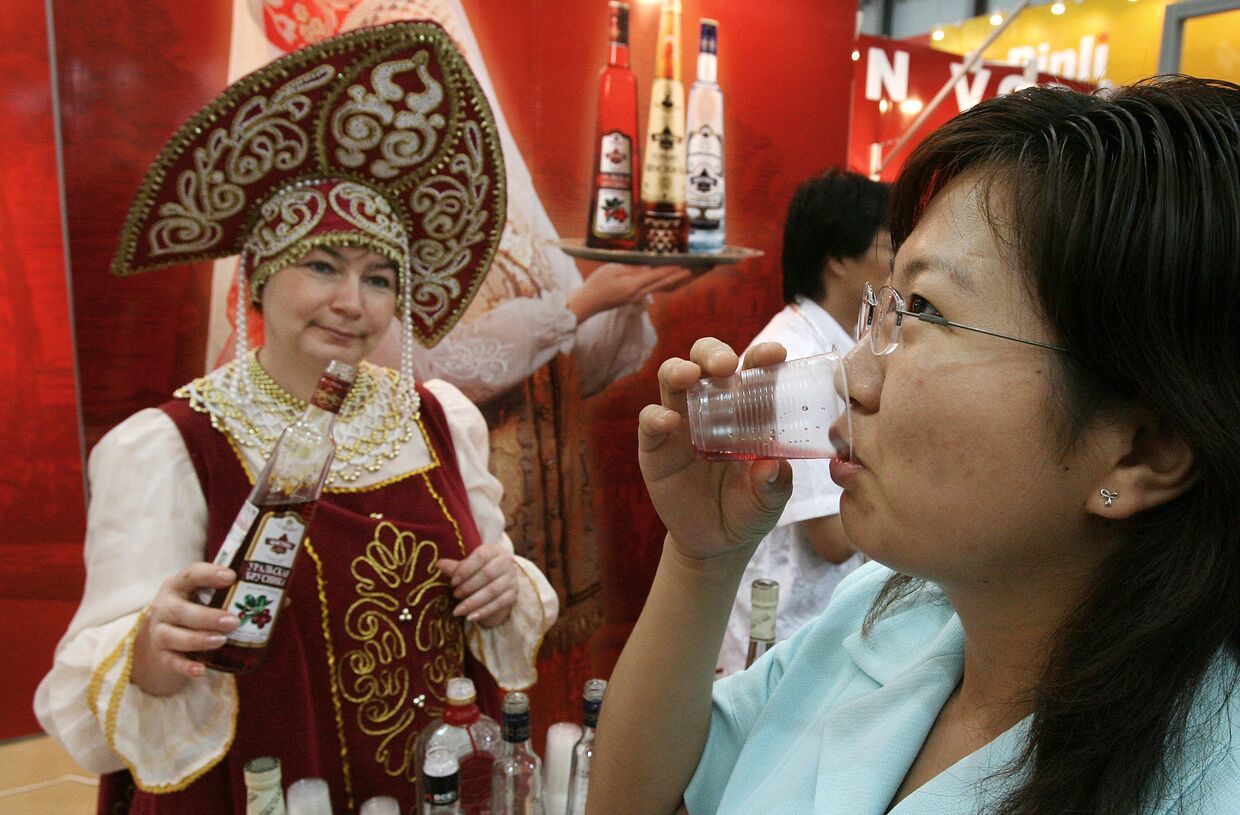 Женщина пробует ягодную водку на выставке российских продуктов в Шанхае