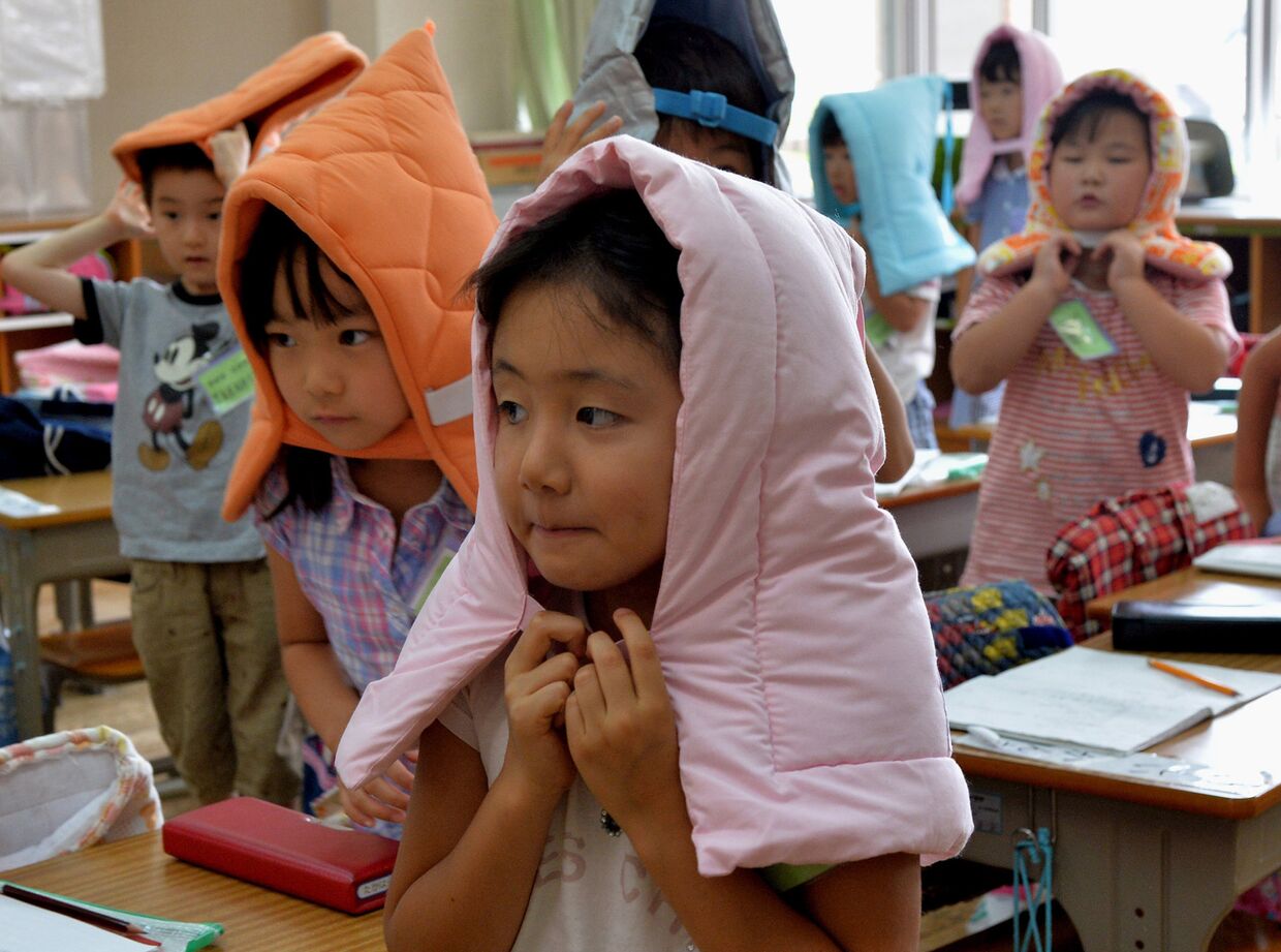 Дети начальной школы в Токио в огнеупорных капюшонах
