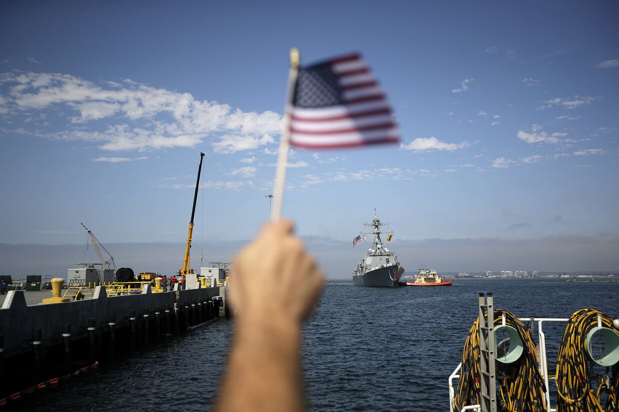Мужчина встречает эскадренный миноносец USS Dewey во время прибытия на военно-морскую базу Сан-Диего