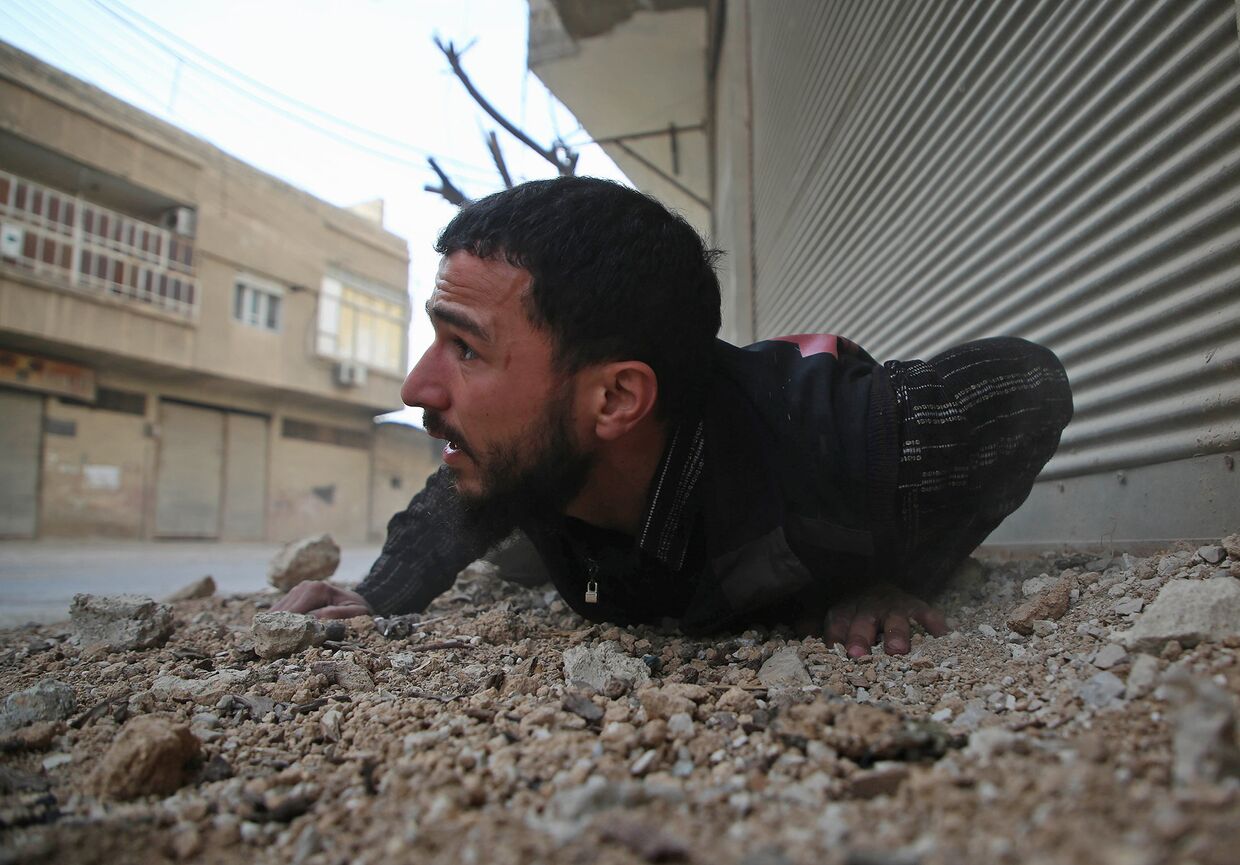 Мужчина укрывается от авиаударов в пригороде Дамаска