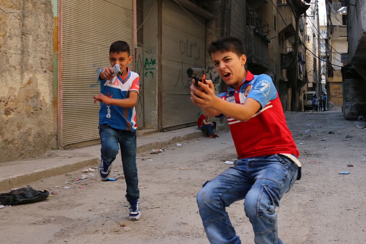 Сирийские дети играют на улице с игрушечным оружием в Алеппо