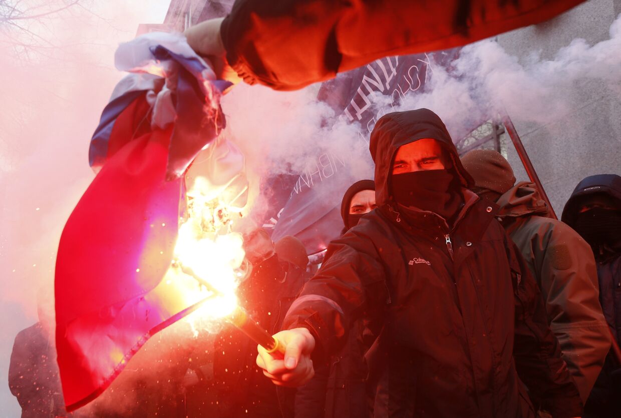 Активисты и сторонники украинских националистических партий сжигают Российский флаг, изьятый из офиса Российского центра науки и культуры в Киеве. 17 февраля 2018
