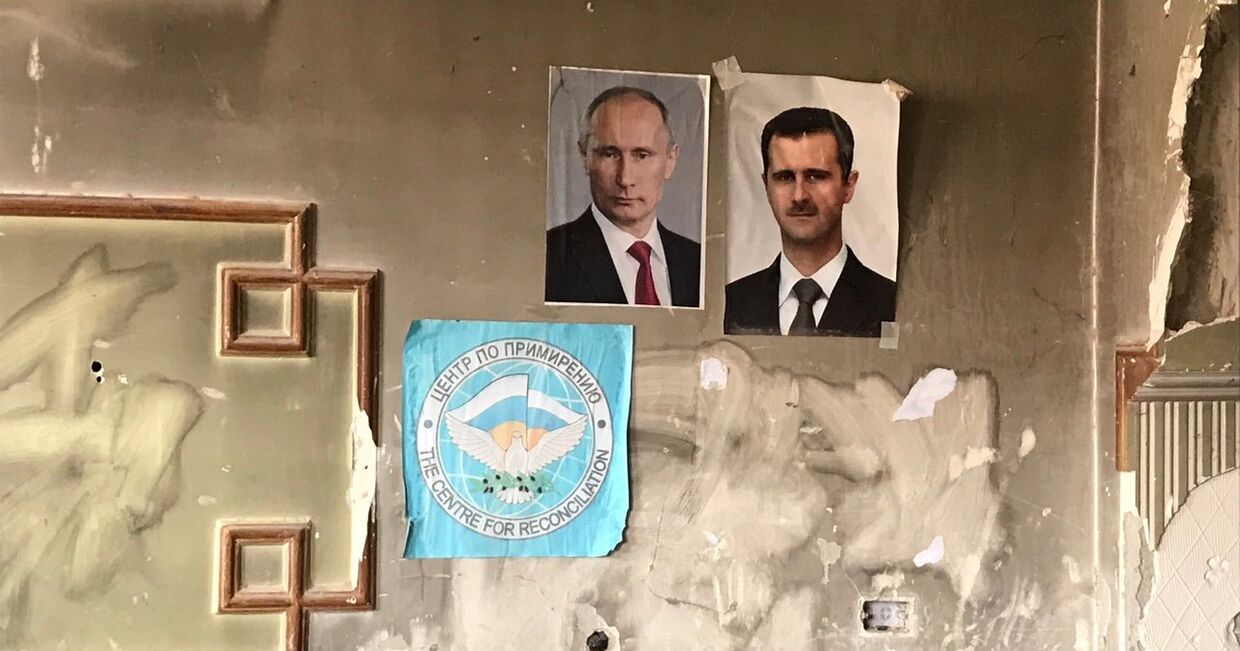 Портреты Владимира Путина и президента Сирии Башара Асада на крайнем КПП армии САР в лагере для Беженцев Вафидин в восточном пригороде Дамаска