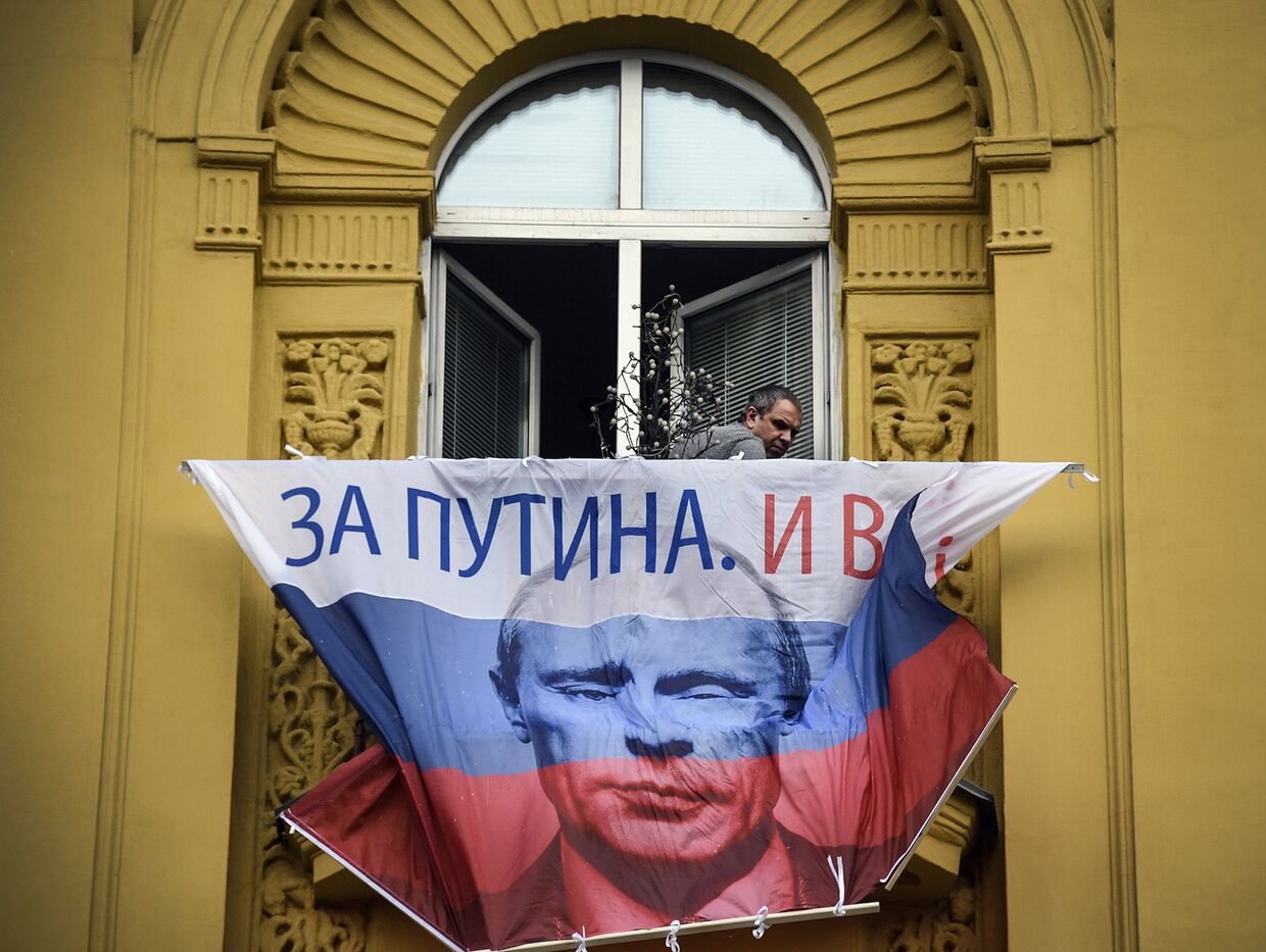 Флаг РФ с портретом Владимира Путина балконе квартиры в Москве