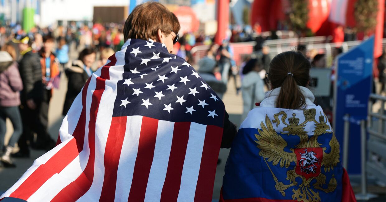 Молодые люди в национальных флагах США и России