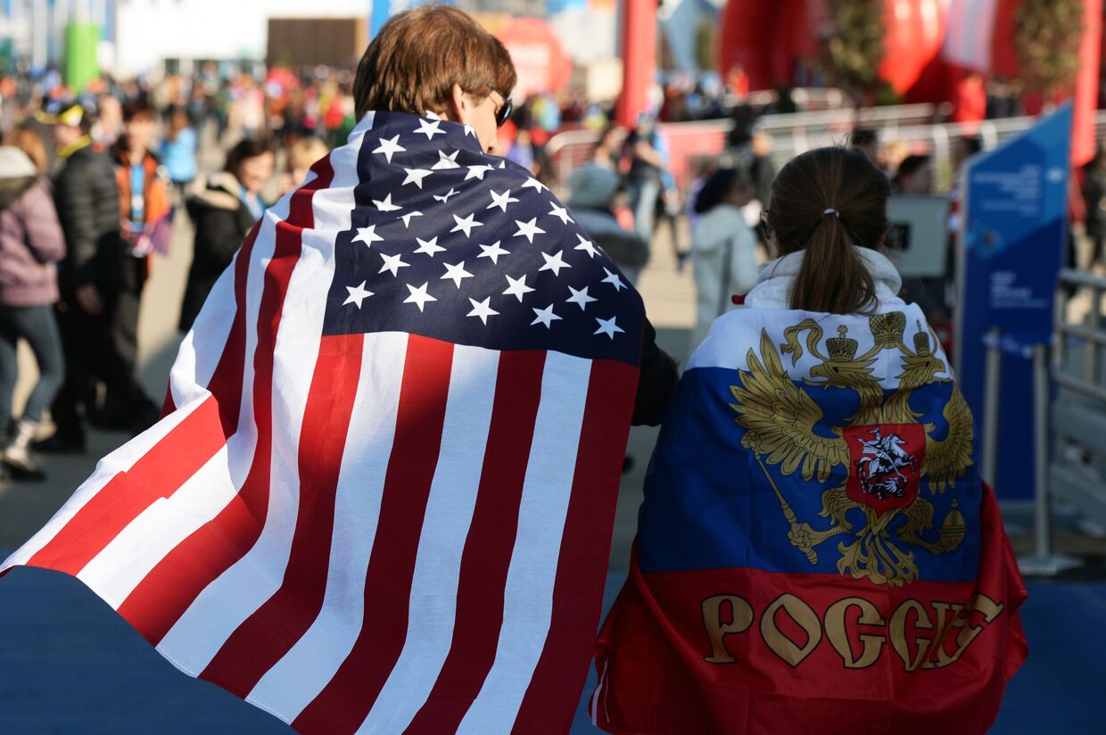 Молодые люди в национальных флагах США и России