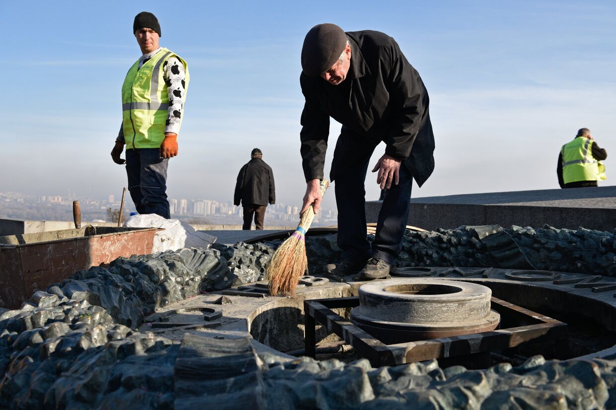Работники Киевгаз очищают вновь залитый цементом мемориал Вечный огонь в парке Славы в Киеве. 20 ноября 2017