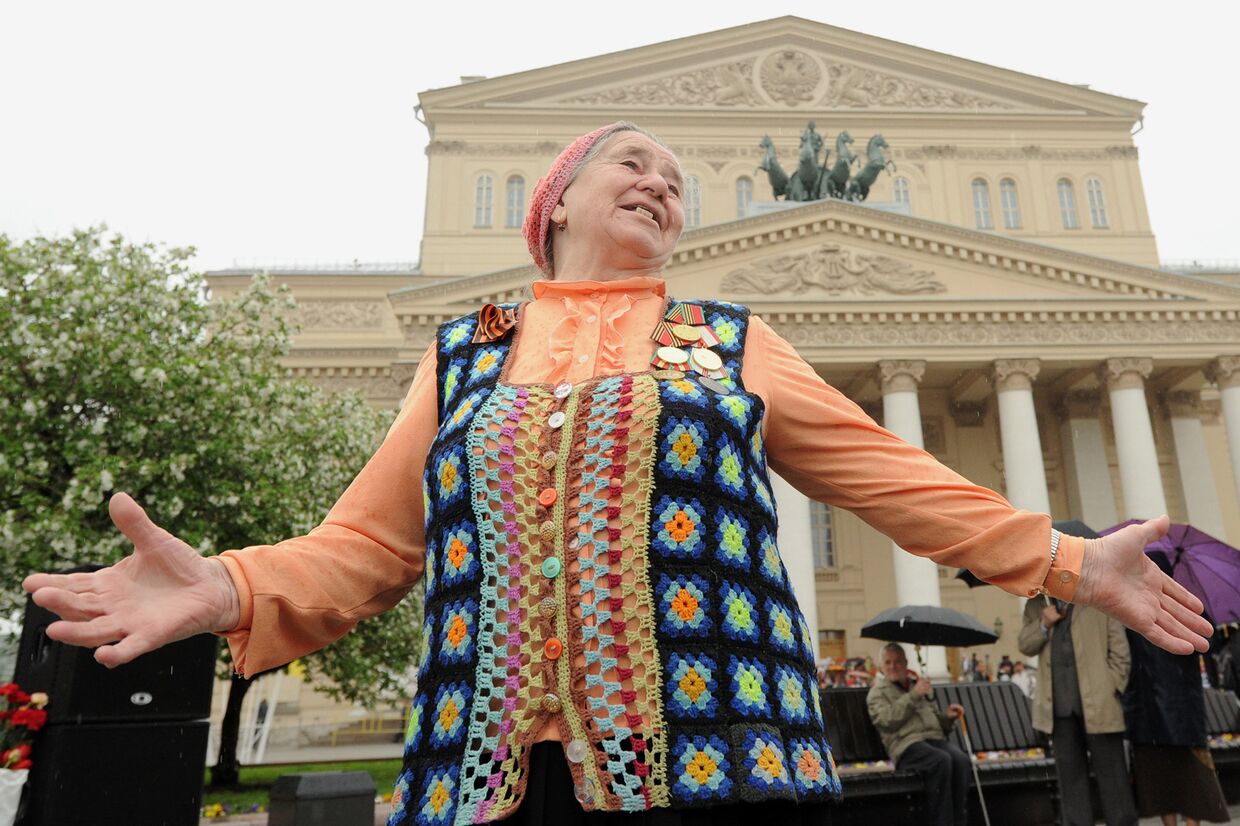Пожилая женщина танцует во время встречи ветеранов в Москве
