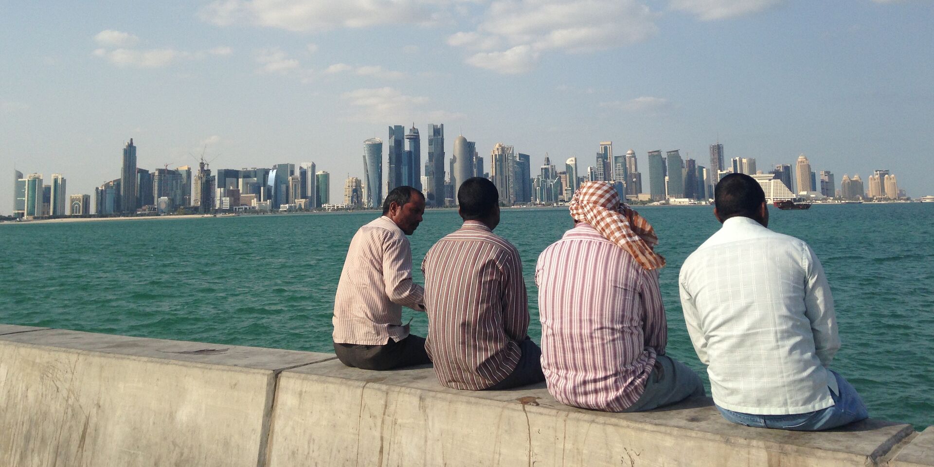 Мужчины сидят на набережной в Дохе, Катар - ИноСМИ, 1920, 07.08.2023